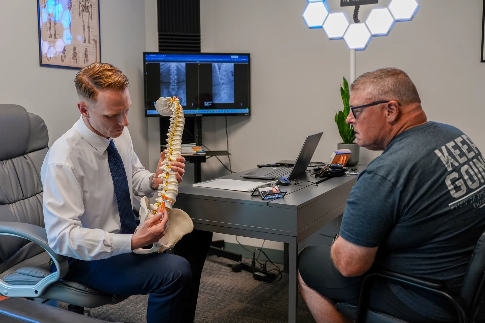 Dr. Ryan Bielecki reviewing spinal X-rays with a patient at SpineCo in Downers Grove, IL