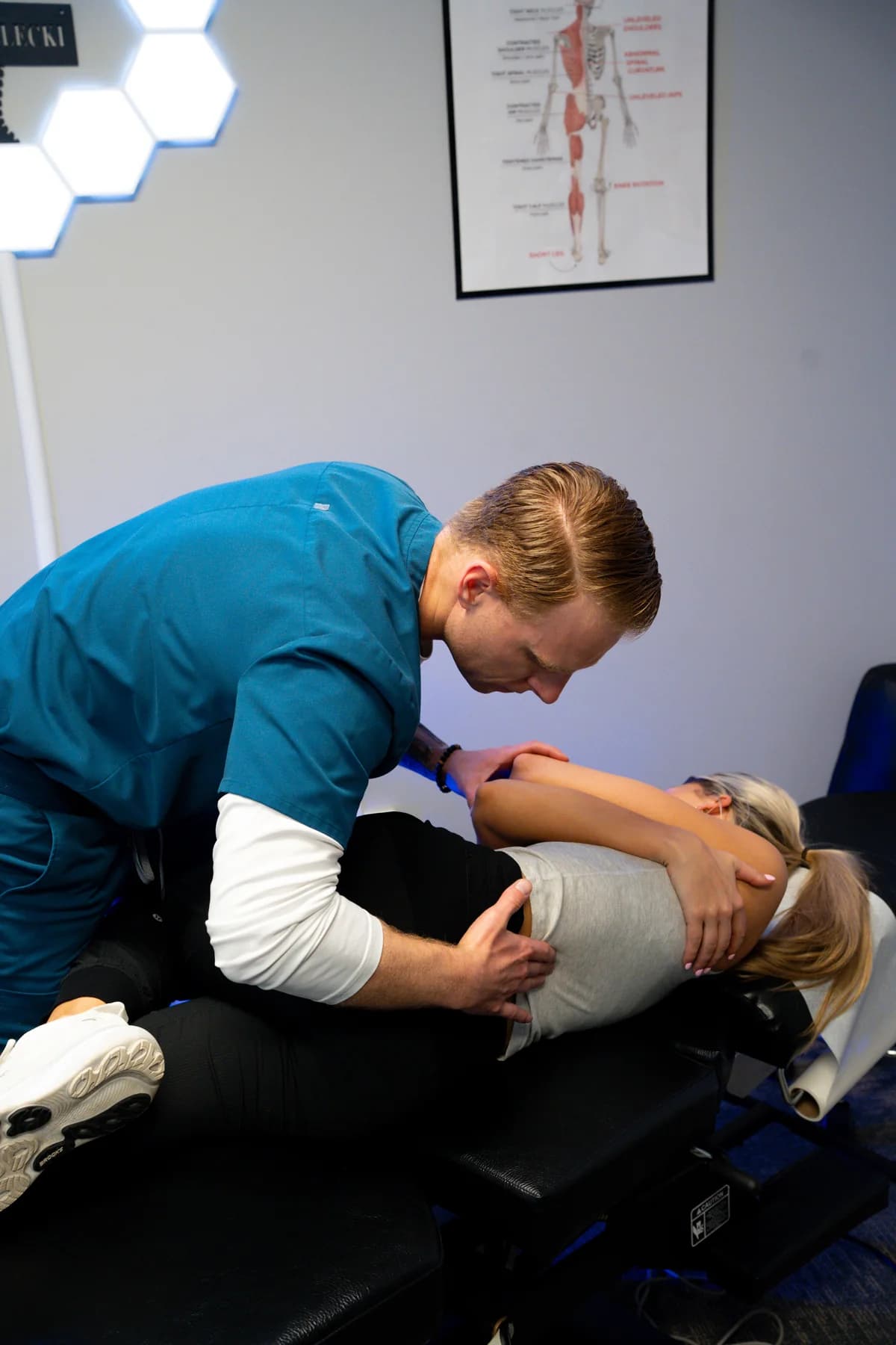 Dr. Ryan Bielecki providing a side-posture chiropractic adjustment at SpineCo in Downers Grove, IL
